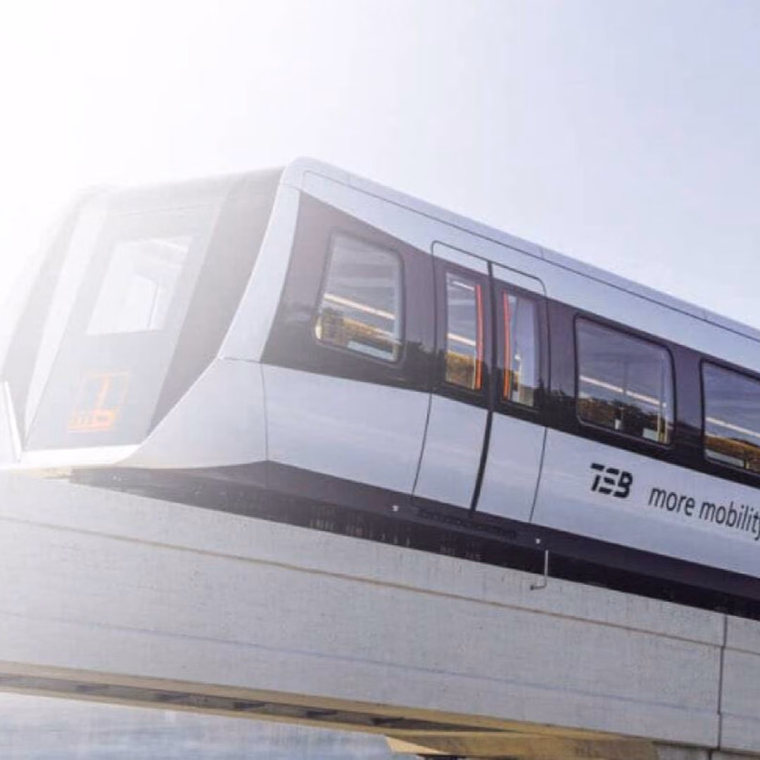 A TSB maglev train seen from below runs along its elevated guideway against a bright sky, the words more mobility on its flank.
