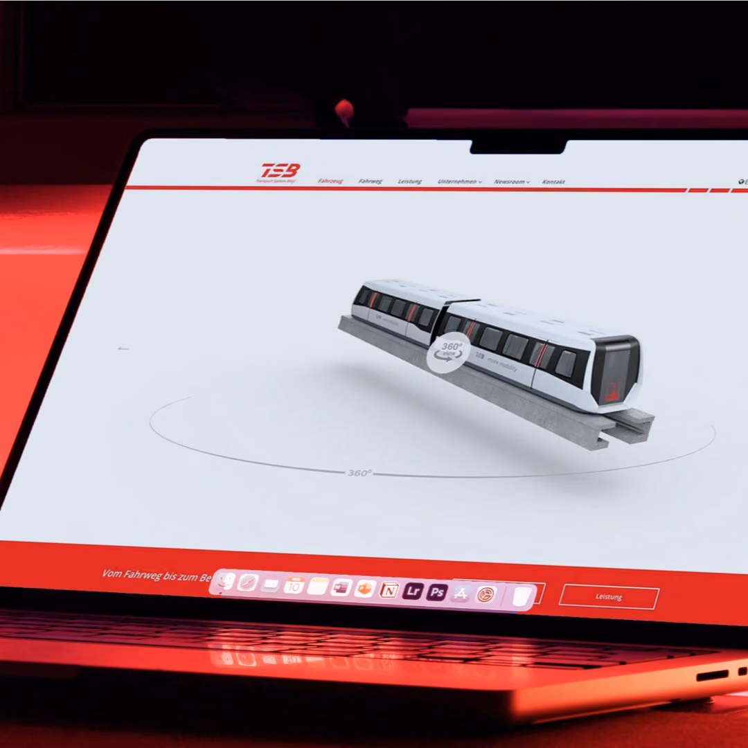 A laptop on a red-lit desk shows the Transport System Boegl website with a rotatable 3D model of the maglev vehicle.