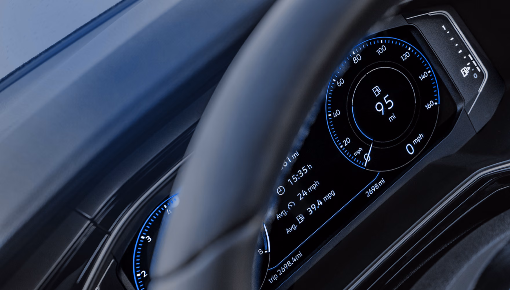 A car's digital instrument cluster glows blue behind the rim of the steering wheel, showing remaining range and trip figures.